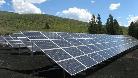 Ground-mounted solar panel array on a hillside