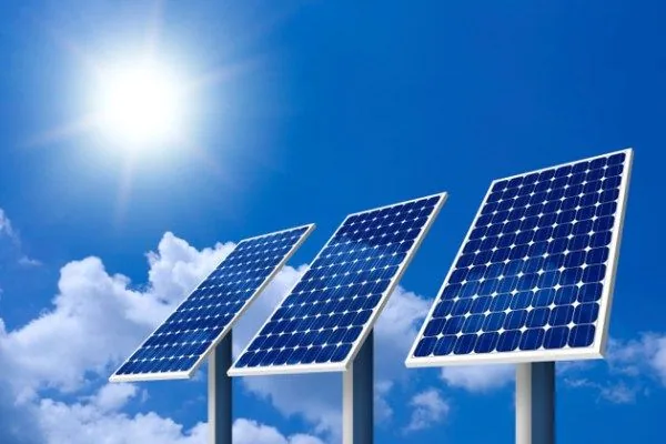 Pole-mounted solar panels against a blue sky