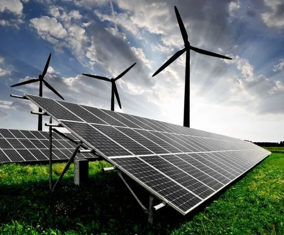 Solar panels with wind turbines in the background