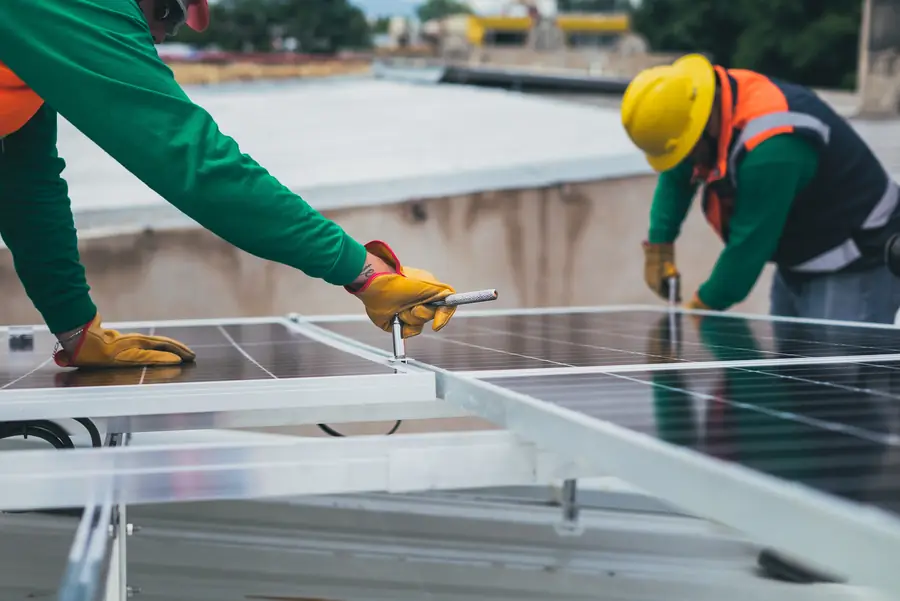 Installation team fixing panel mounting on a roof